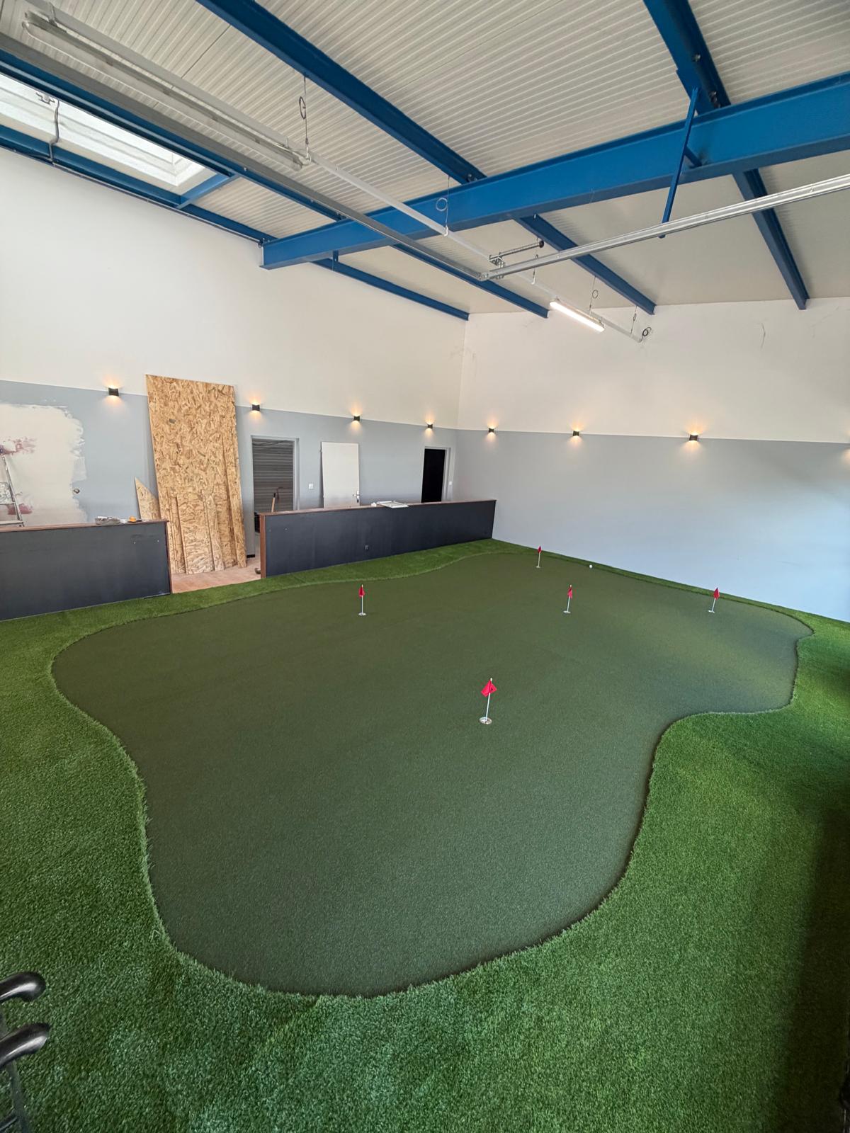 Putting green indoor avec drapeaux au Golf Lab Douvaine construit par Addon Golf